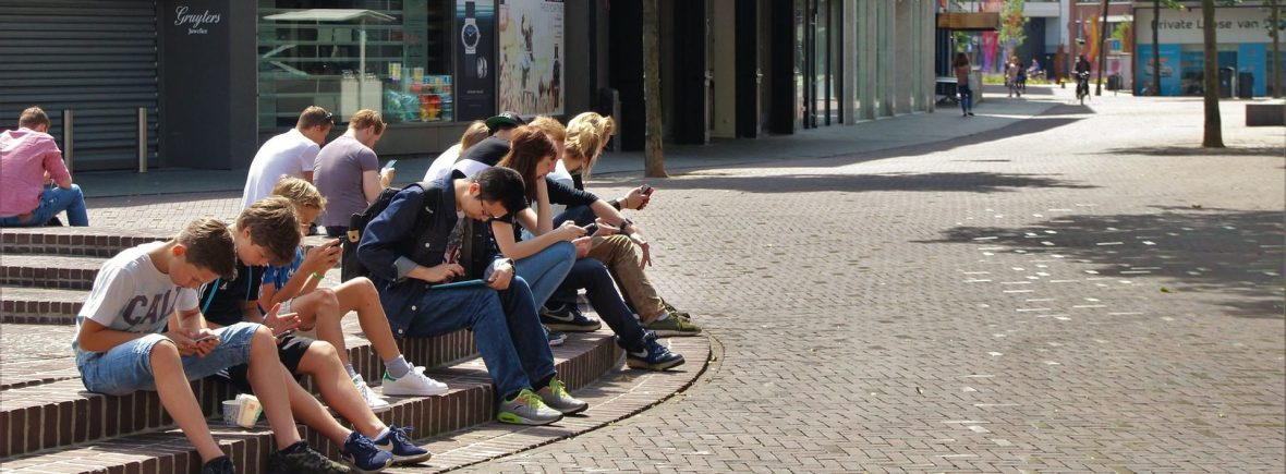 une groupe d'adolescents assis la tête dans leur smartphone ou I-phone